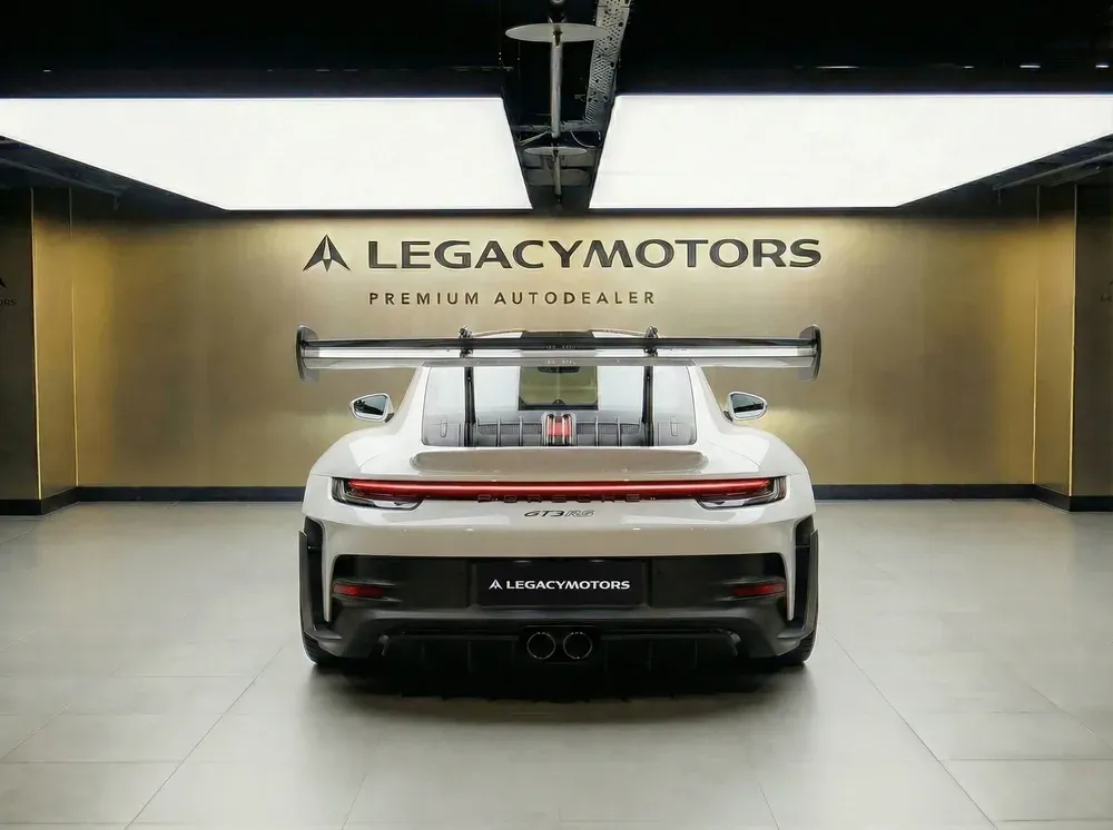 Белый Porsche 911 GT3 RS с антикрылом, вид сзади в шоуруме Legacy Motors